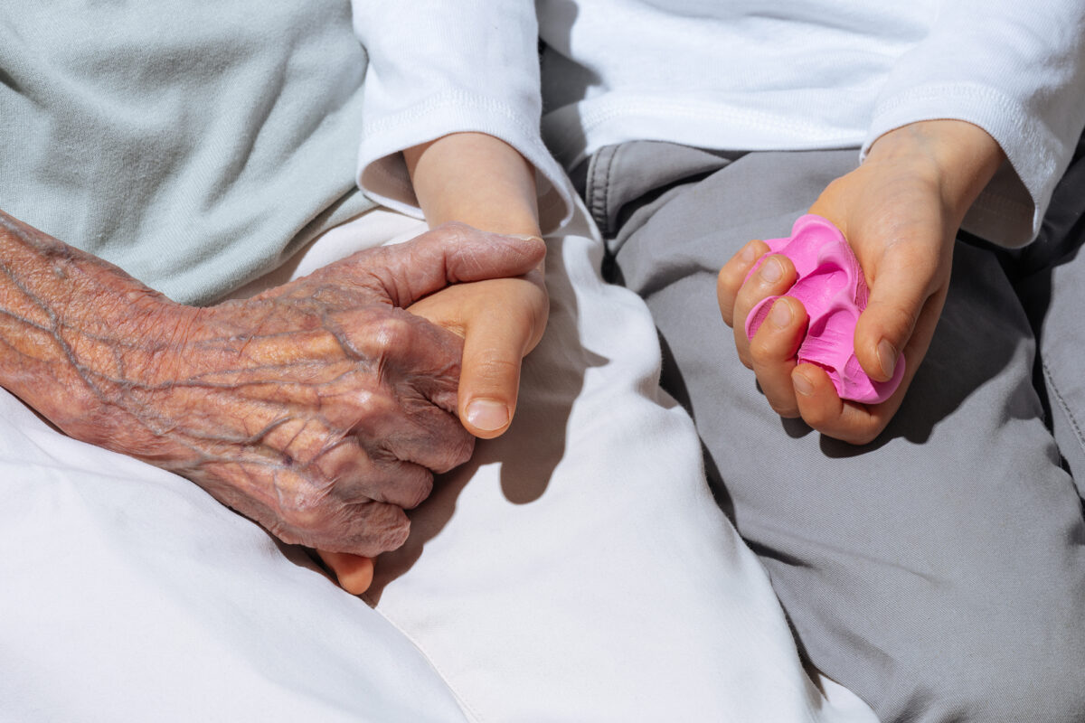 a child and his granny hold hands and a handprint as a consolation gift